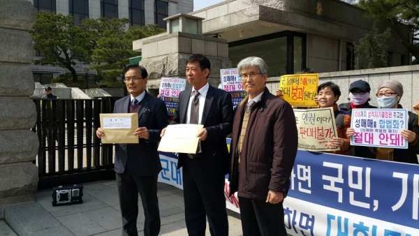 오직예수사랑선교회 관계자들이 성명서 등을 헌법재판관들에게 전달하기 위해 헌재 내로 들어가려 하고 있다.