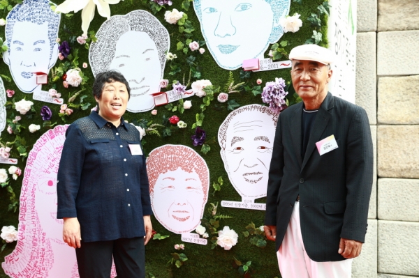 생명의 벽에 전시된 초상화 앞에 선 부부 신장기증인 김근묵, 이경희 부부