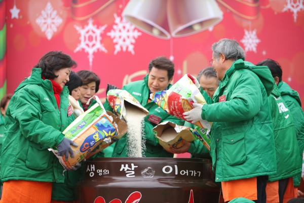 라이스팟 릴레이(생쌀이운동)를 위해 참가자들이 독에 쌀을 붓고 있다.