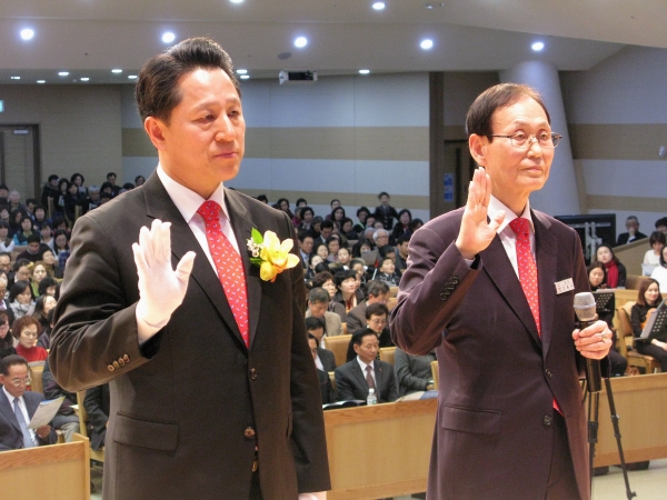 신길교회 신임 담임목사인 이기용 목사(왼쪽)가 교회대표와 함께 서약하고 있다.