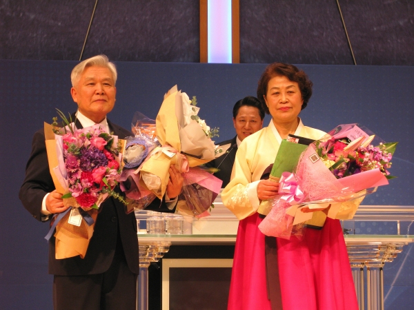 신길교회 원로목사로 추대 받은 이신웅 목사(왼쪽) 내외가 꽃다발을 받고 인사를 전하고 있다.