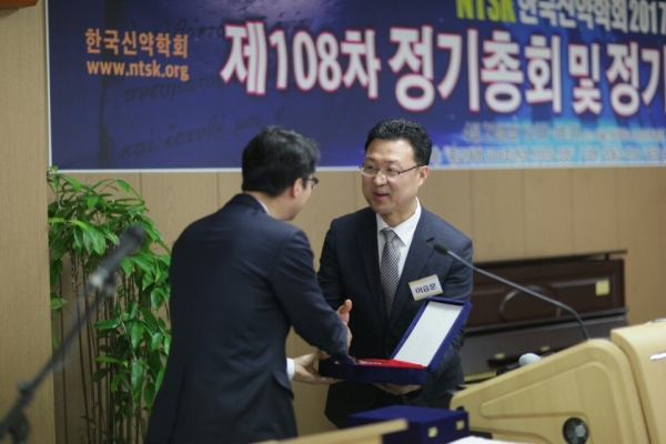 한국신약학회 윤철원 직전회장이 지난 2년 동안 수고한 이승문 총무에게 공로패를 증정하고 있다.