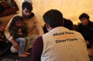 시리아 북서부에 위치한 임시 대피소에서 이재민 가정을 만나고 있는 시리아월드비전 직원의 모습