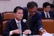 김영호 통일부 장관 후보자가 21일 오후 서울 여의도 국회에서 열린 인사청문회에서 자료를 전달받고 있다. 
