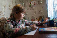 우크라이나 헤르손 지역으로 귀환한 안나(12세, 가명)가 스마트폰을 이용해 온라인 수업에 참여하고 있는 모습