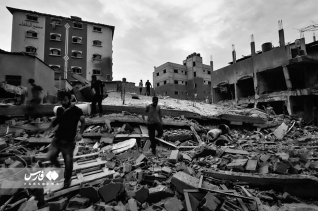 가자 지구의 무너진 건물더미 위로 사람들이 이동하고 있다.