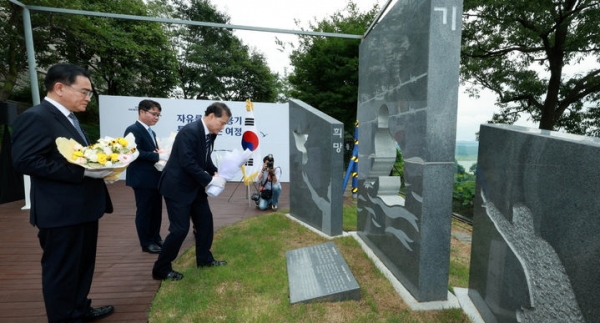 김영호 통일부 장관이 1일 오전 경기 파주시 탄현면 오두산 전망대 뒤뜰에서 열린 북한이탈주민의 날 기념 조형물 제막식에서 헌화 하고 있다. 왼쪽부터 태영호 민주평화통일자문회의 사무처장, 김 장관, 지성호 전 국회의원.