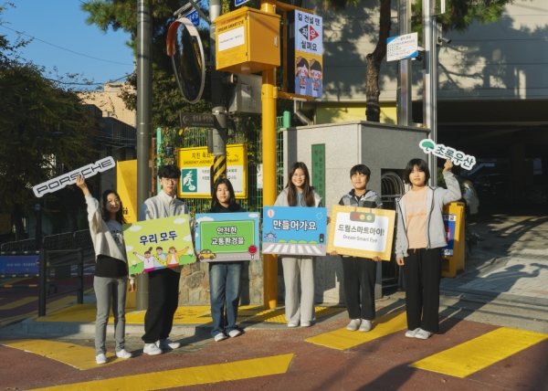 초록우산과 포르쉐코리아의 사회공헌 협력 사업 ‘포르쉐 드림 스마트아이‘가 적용된 서울 신봉초등학교 앞에서 학생들이 기념촬영을 하고 있다