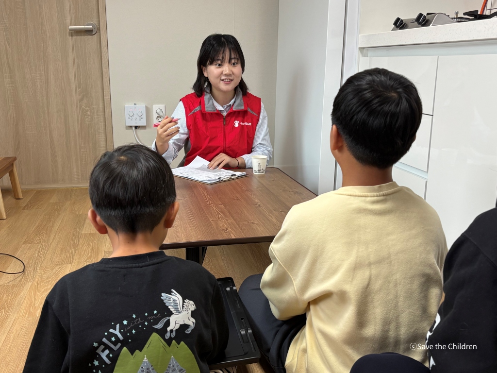 산불 피해 아동 가정 정기 모니터링을 위해 방문한 세이브더칠드런  직원이 아동들과 이야기를 나누고 있다