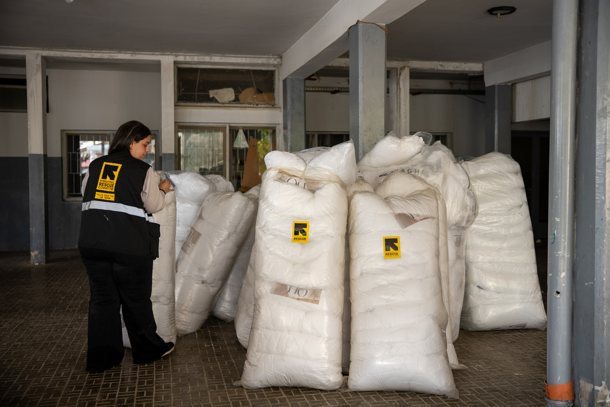 레바논 아카르(Akkar) 지역 공동 대피소에서 국제구조위원회 직원이 분쟁 격화로 강제 이주한 피난민들을 위해 침구를 준비하는 모습