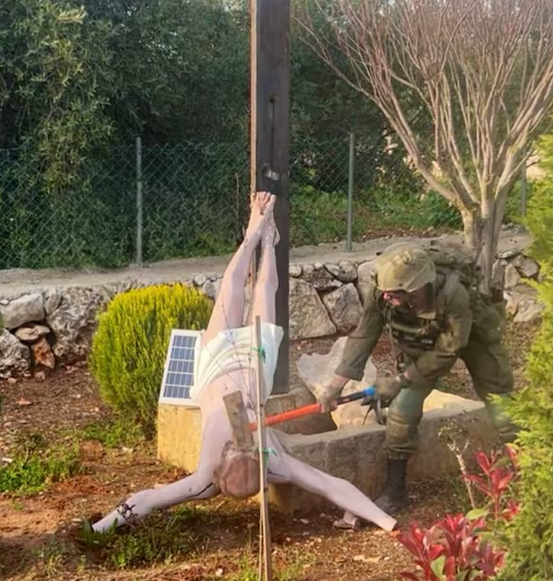이스라엘 병사가 예수 그리스도상을 훼손하고 있다
