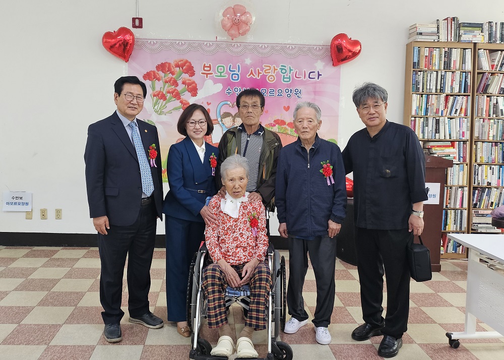 김성만 목사와 이인혜 원장이 요양원 노인들과 함께 기념촬영하고 있다