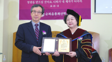 순복음총회신학교 제3대 총장으로 취임한 유영희 목사(오른쪽)가 이사장 이성근 교수로부터 취임패를 전달받고 있다.