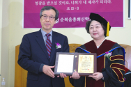 순복음총회신학교 제3대 총장으로 취임한 유영희 목사(오른쪽)가 이사장 이성근 교수로부터 취임패를 전달받고 있다.