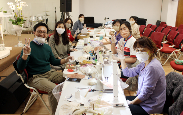 강단 앞에 임시로 간이 작업대를 설치하고 마스크 제작에 한창인 LA 백송교회 성도들. 무료로 보급되는 면 마스크를 현대적 감각으로 남성용, 여성성, 아동용으로 제작하고 있다.