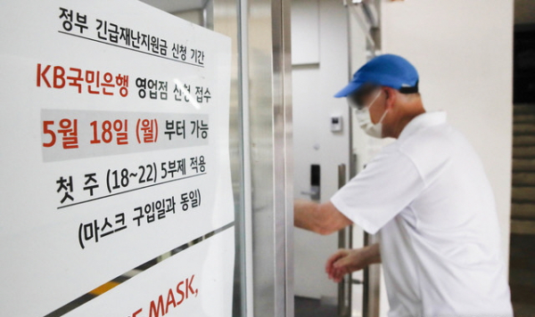 정부 긴급재난지원금 신청 접수 안내문이 17일 오후 서울 시내의 한 KB국민은행 영업점 입구에 부착돼 있다. 정부 긴급재난지원금은 오는 18일부터 시중은행 및 읍면동 주민센터에서 오프라인으로 신청할 수 있다.