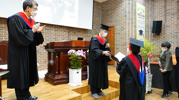 이태재 학장이 졸업생 이은희 사모(풍성한교회)에 성적 우수상을 전달하고 있다.