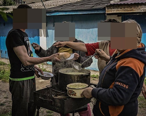 우크라이나 전쟁 난민이 배급받은 식량으로 요리를 하고 있다.